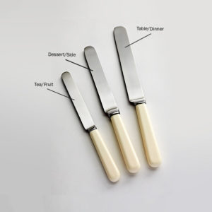 Cream handled knife with round candle end and elegant parallel blade.